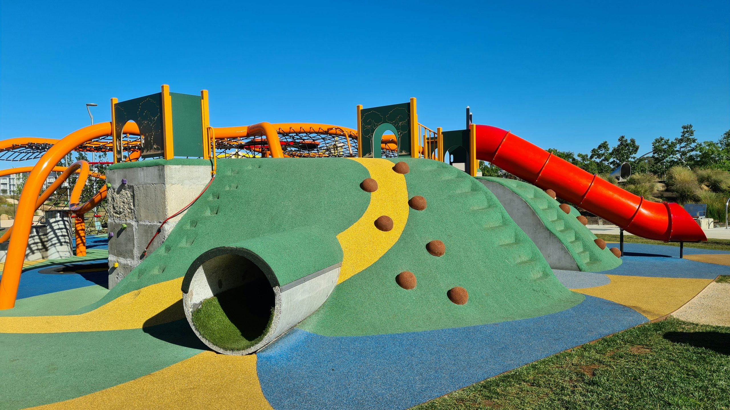 Colourful Playground with tunnels, slides, climbing grips in the sun